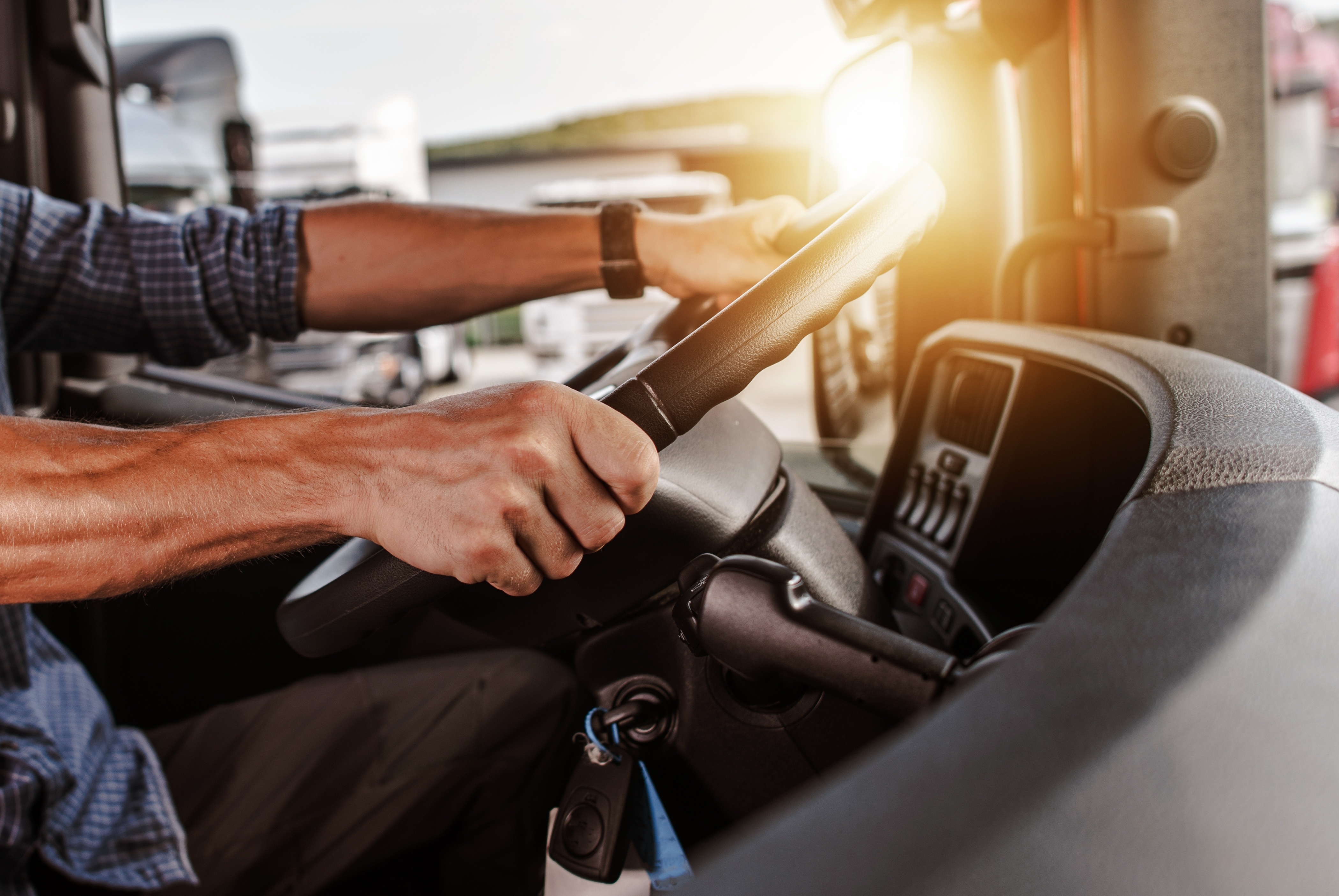 Close up of truck driver holding steering wheel