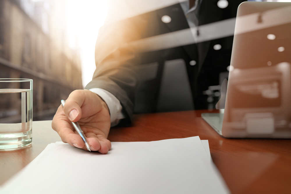 double exposure of businessman handing over a contract on a desk