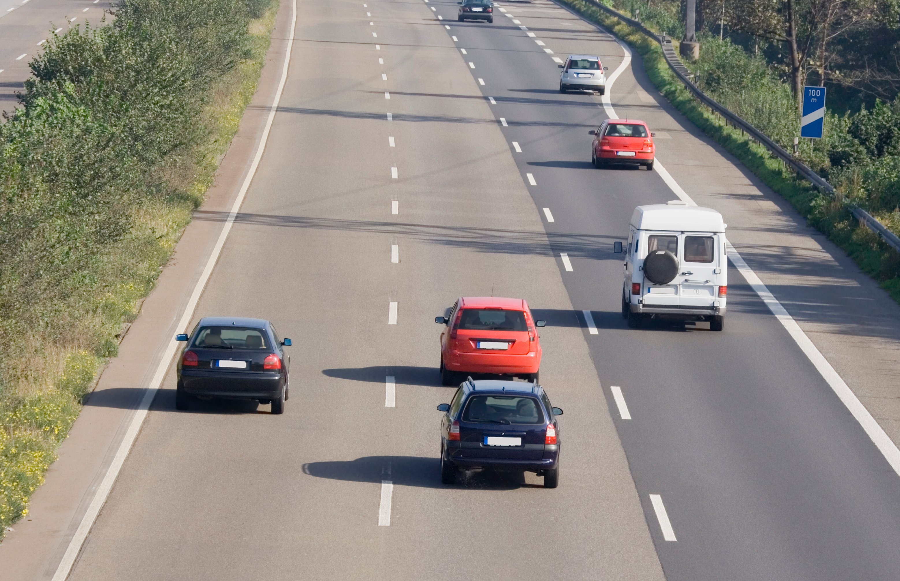 cars traveling on three-lane road