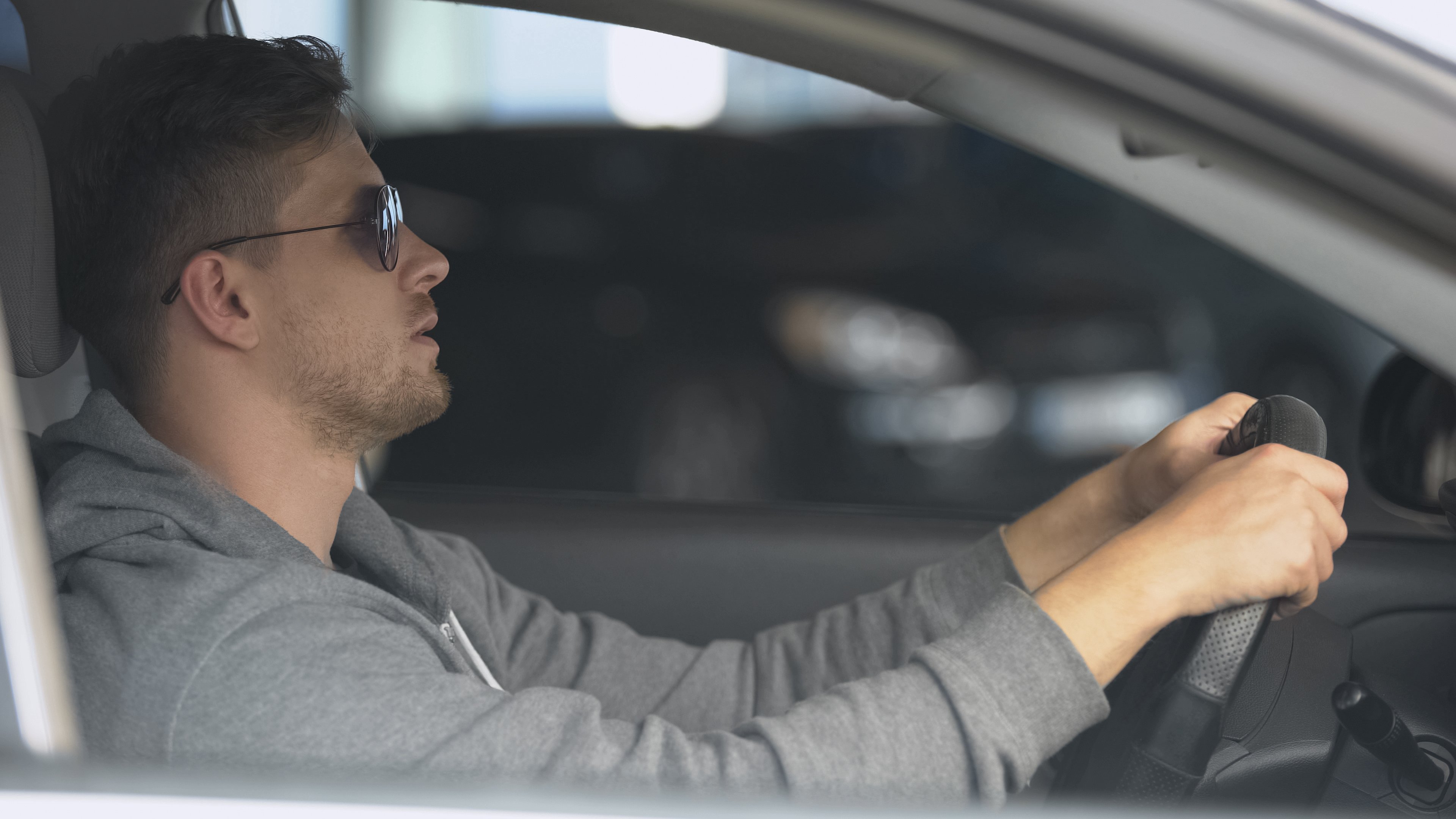 Man in sunglasses driving under the influence