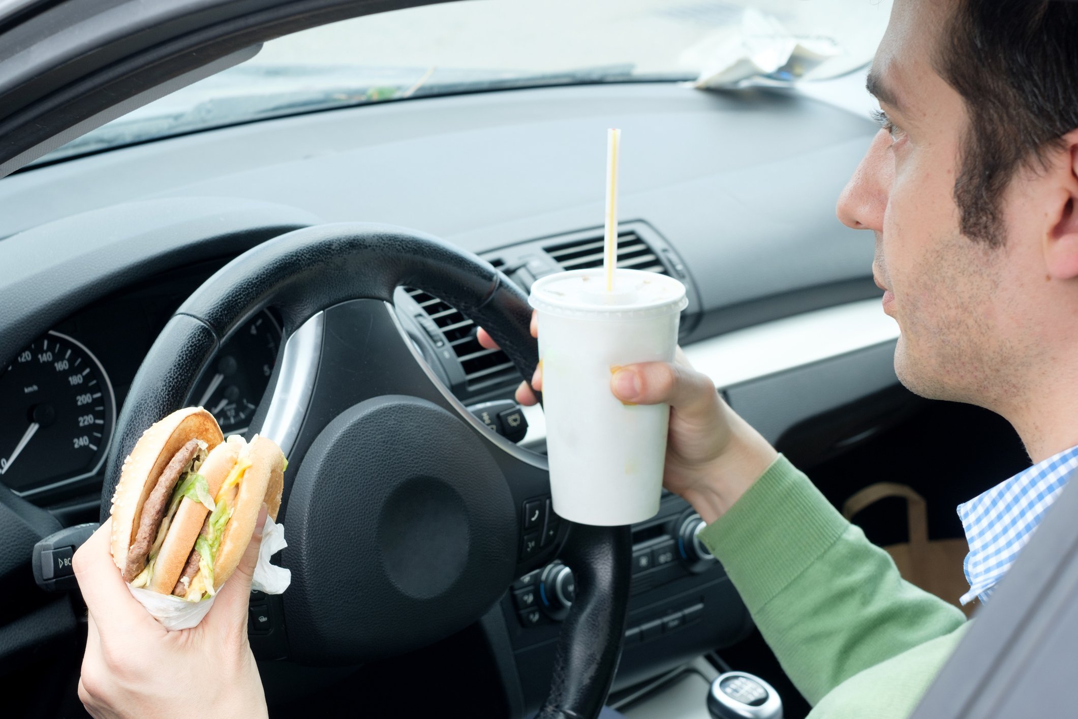 Man eating and drinking while driving