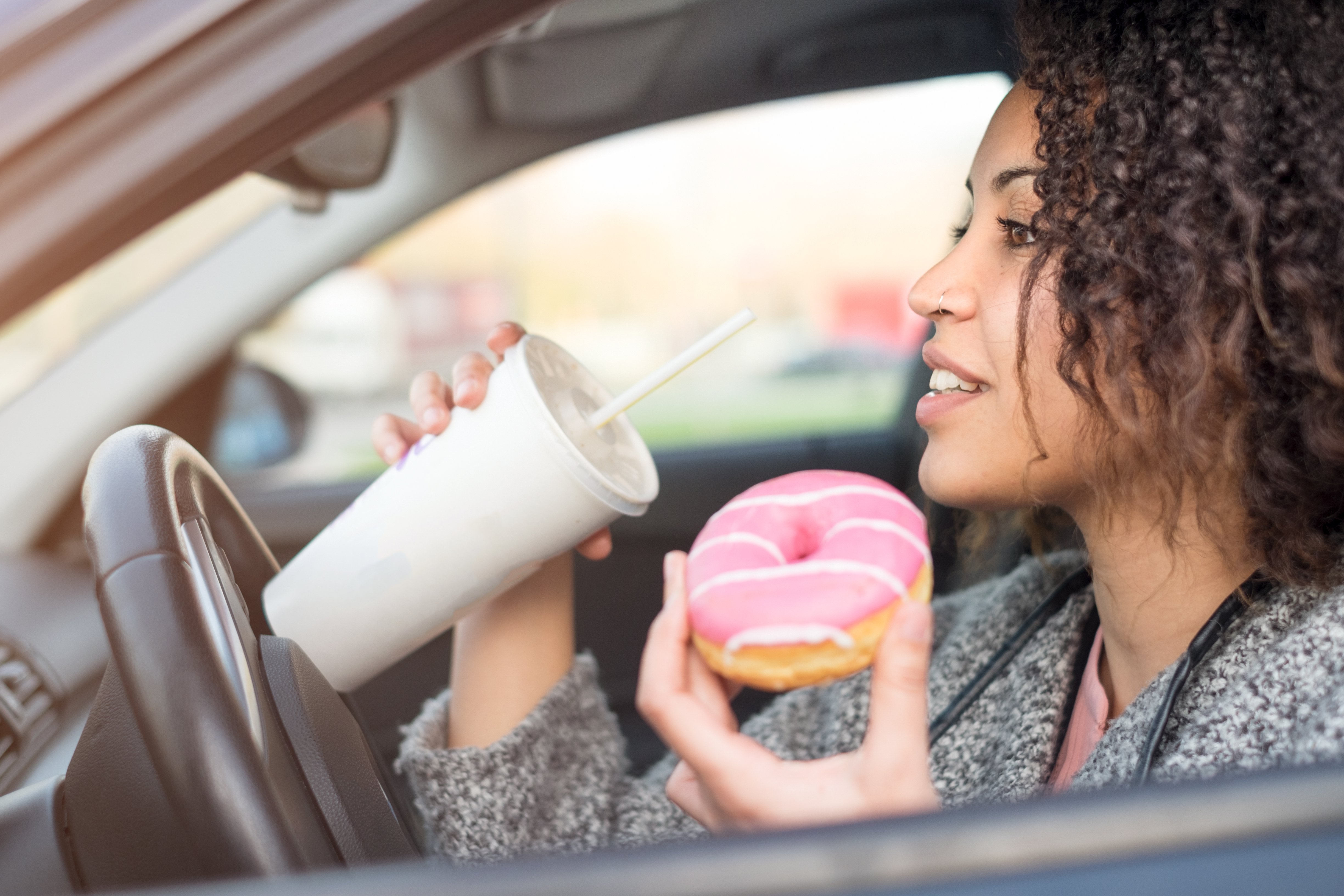 Woman eating and drinking while driving