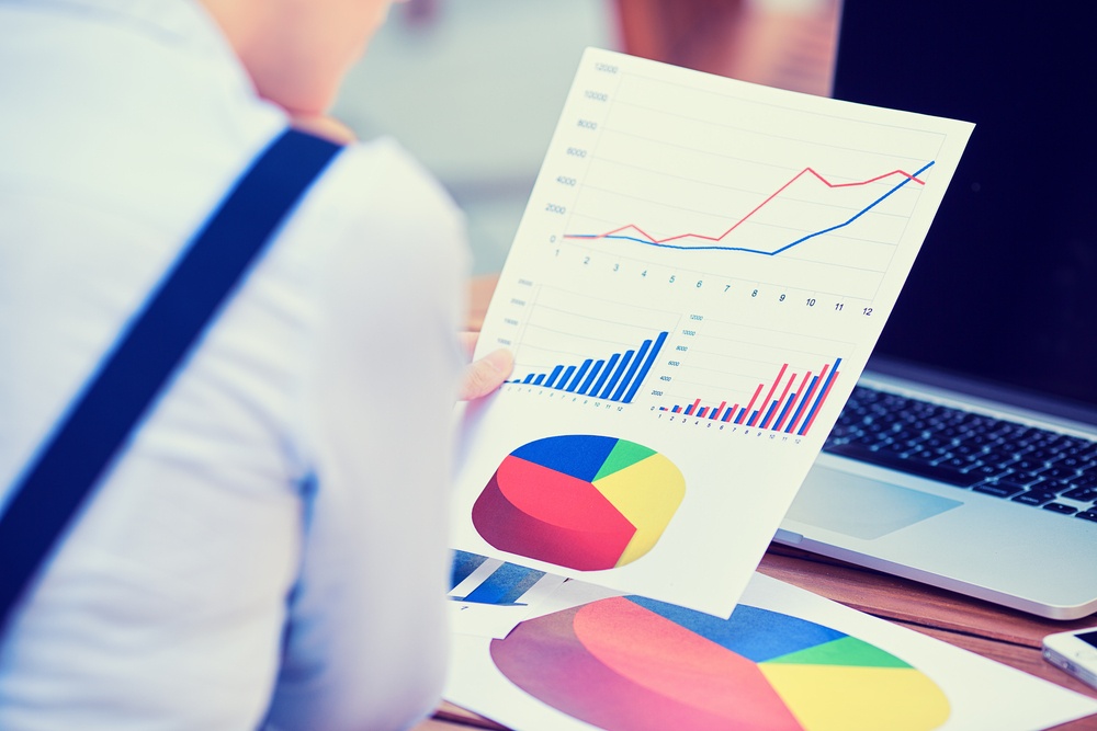 Man looking at paper with charts